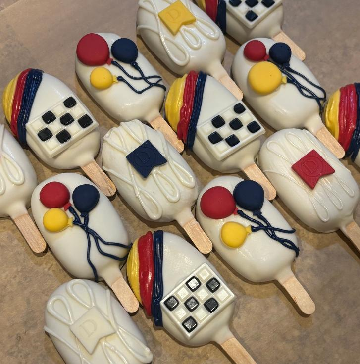 Graduation themed cakesicles with caps and diplomas
